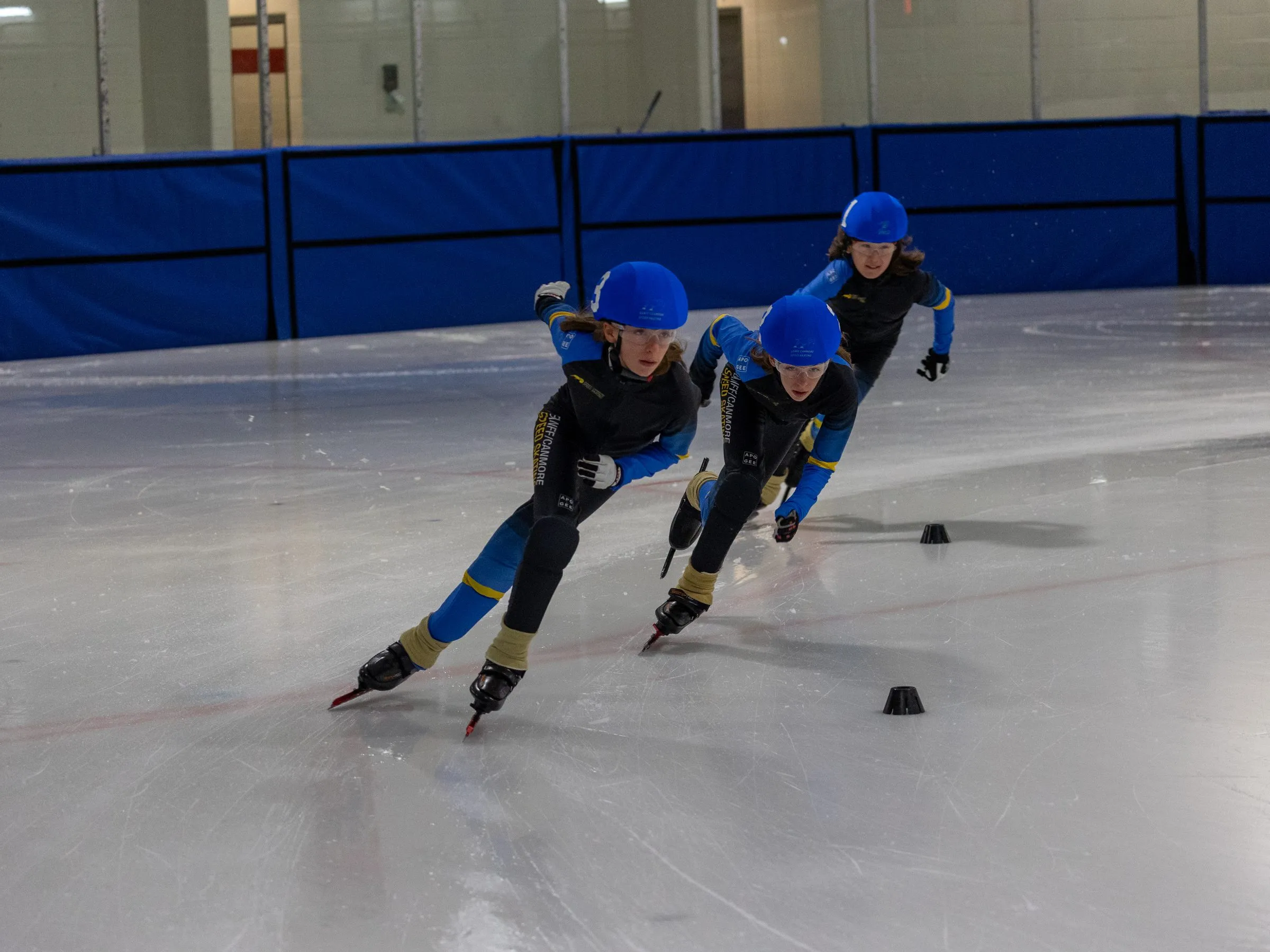 Club skaters leaning through a corner during a race