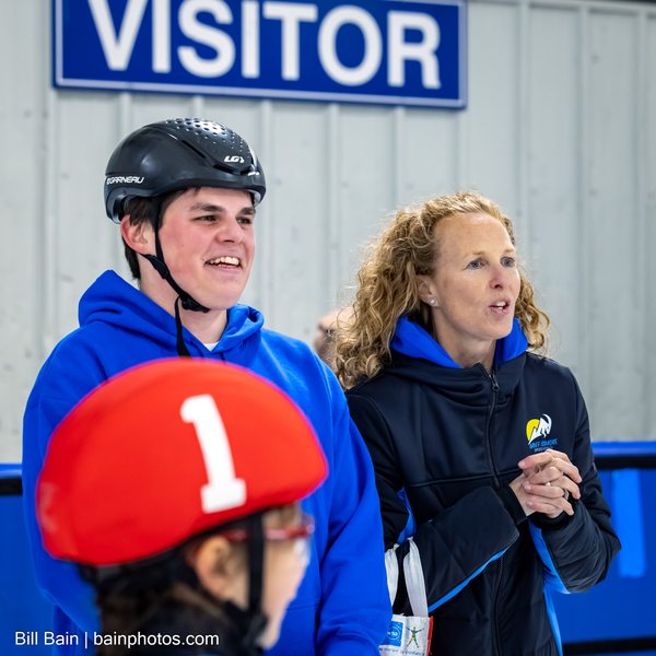 Coaches in club hoodies smiling at the boards